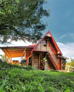 drewniany domek z werandą i drzewem w obiekcie Log cabin Uvac (Vikendica Saponjic) w mieście Nova Varoš