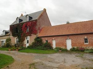 a brick building with ivy on the side of it at La Ferme du Parc in Pendé