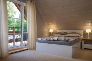 sypialnia z łóżkiem i dużym oknem w obiekcie KARKONOSKIE CHATY w Szklarskiej Porębie