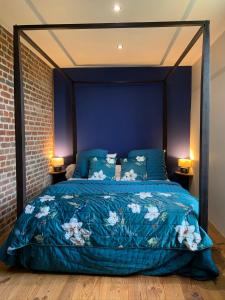 a bedroom with a bed with a blue comforter at Gîtes du Grand Bois in Maubeuge