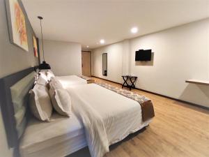 Postel nebo postele na pokoji v ubytování Apple Suites Hotel