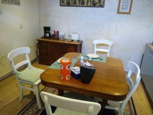 a wooden table with white chairs and a wooden table and chairsktop at Folmerhuis in Oostkapelle