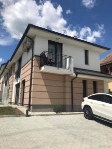 biały samochód zaparkowany przed domem w obiekcie Edmond Apartment w Hévízie