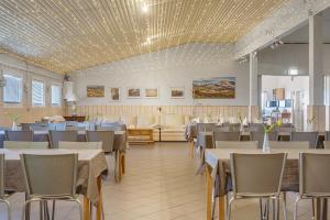 a dining room with tables and chairs and ceilings at Guesthouse Vatnsholt in Vatnsholt