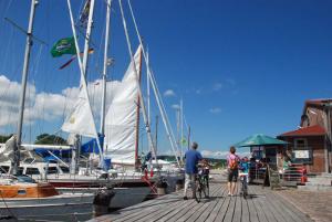 a group of people standing on a dock near a sail boat at Ferienwohnung mit Balkon in Baeder in Ostseebad Sellin