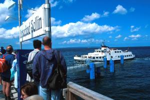a group of people standing on a pier looking at a boat at Ferienwohnung mit Balkon in Baeder in Ostseebad Sellin