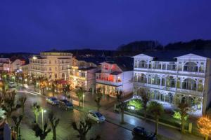 a city at night with cars parked in a parking lot at Ferienwohnung mit Balkon in Baeder in Ostseebad Sellin +9 photos