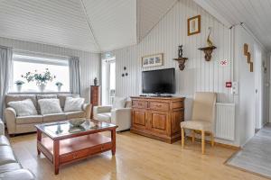 a living room with a couch and a tv at Guesthouse Vatnsholt in Vatnsholt