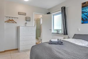 a bedroom with a bed and a dresser and a window at Guesthouse Vatnsholt in Vatnsholt +37 photos