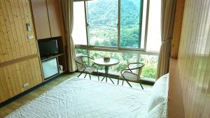 una stanza con tavolo e sedie e una grande finestra di Very Happy Homestay a Pingxi