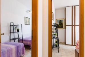 una habitación con cama y una habitación con estanterías en Cortina 1-83, en Lido di Pomposa