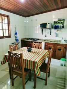 a kitchen with a table and chairs and a stove at Aconchego de Regina in Tiradentes