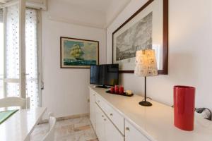Habitación con escritorio, TV y lámpara. en Cortina 1-83, en Lido di Pomposa