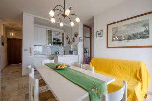 a kitchen and dining room with a white table and chairs at Cortina 1-83 in Lido di Pomposa +22 photos