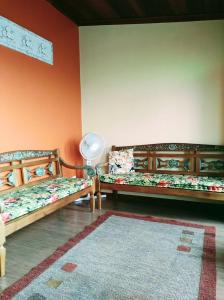 a room with two beds and a fan on the wall at Aconchego de Regina in Tiradentes