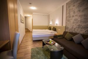 sala de estar con cama y sofá en Apart Garni Monte Vera, en Sankt Anton am Arlberg