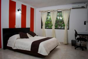 a bedroom with a bed with red and white stripes at Hotel Nova Park in Arauca