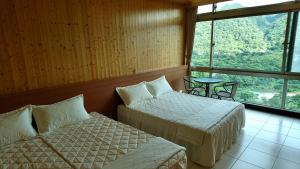 a room with two beds and a table and a window at Very Happy Homestay in Pingxi