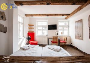 two beds in a room with a table and chairs at Living inStyle in Krems an der Donau