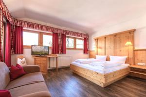 een hotelkamer met een bed en een bank bij Bruggerhof in Fulpmes