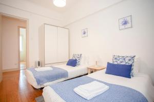 duas camas num quarto com azul e branco em Liiiving in Porto | Light Spacious Apartment no Porto