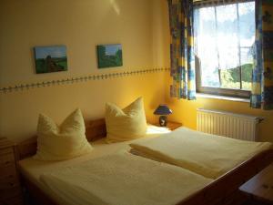- une chambre avec un lit doté de draps blancs et une fenêtre dans l'établissement Ferienwohnung Weingart Quedlinburg, à Quedlinbourg