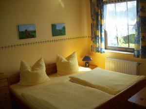 Schlafzimmer mit einem Bett mit weißer Bettwäsche und einem Fenster in der Unterkunft Ferienwohnung Weingart Quedlinburg in Quedlinburg