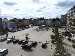 ein Parkplatz mit Autos in einer Stadt geparkt in der Unterkunft Hotel Cecil in De Panne