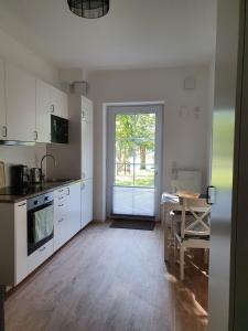 a kitchen with white cabinets and a table and a window at Ferienwohnungen Unter den Eichen in Stade