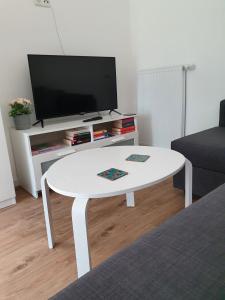 a white coffee table in a living room with a tv at Ferienwohnungen Unter den Eichen in Stade