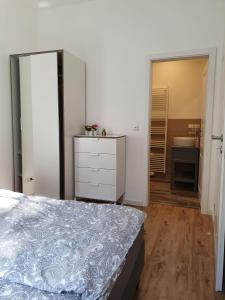 a bedroom with a bed and a bathroom with a sink at Ferienwohnungen Unter den Eichen in Stade
