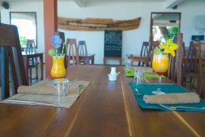 a wooden table with two vases with flowers in it at Nosy Lodge in Nosy Be