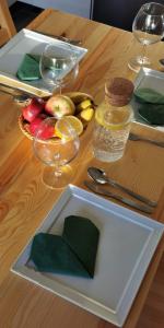 a wooden table with a plate of fruit and wine glasses at Apartament Highway To Hel in Hel
