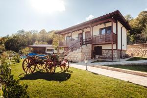 a horse drawn carriage in front of a house at Guest House Hristova Kashta - Христова Къща in Cherni Vrŭkh