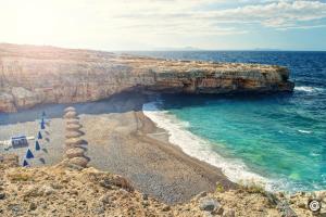 vista su una spiaggia con oceano e scogliera di Matthias Hotel Apartments ad Adelianos Kampos