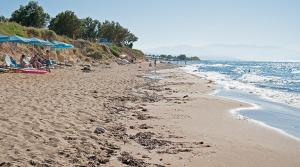 una playa con gente y sombrillas y el océano en Matthias Hotel Apartments, en Adelianos Kampos