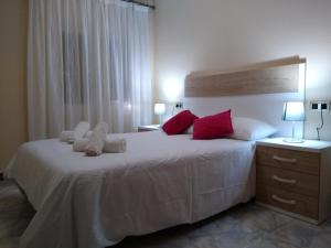 a bedroom with a large white bed with red pillows at Apartamentos La Rosa - Calamocha in Calamocha