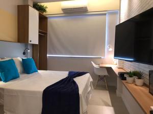 um quarto com uma cama e uma televisão de ecrã plano em Studio Praia Copacabana Beach no Rio de Janeiro