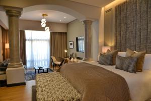 
a bedroom with a large bed and a large window at Apogee Boutique Hotel & Spa in Pretoria
