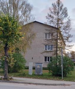 uma casa de tijolos ao lado de uma rua em Dzīvoklis 17 em Rūjiena