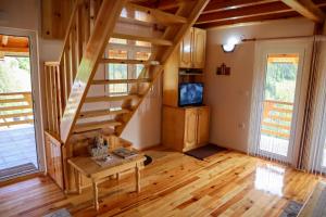 uma sala de estar com uma escada de madeira numa casa em Adamov Konak Apartmani em Lazići
