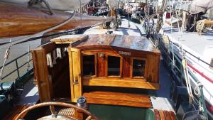 Tjalkjacht Pelikaan Lemmer في ليمير: قارب مع كابينة خشبية على السطح