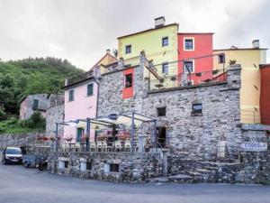 un grande edificio in pietra con un'auto parcheggiata di fronte di Casa San Bartolomeo a Riccò del Golfo di Spezia