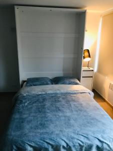 - une chambre avec un grand lit et une couverture bleue dans l'établissement Terrasses de Malmedy Studio 332, à Malmedy