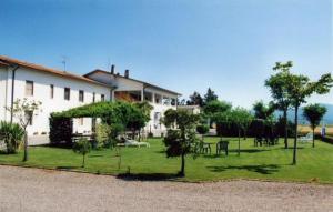 une maison avec une cour arborée devant elle dans l'établissement Agriturismo Magnaboschi, à Alberese
