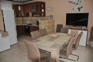 - une cuisine avec une table et des chaises en bois dans la chambre dans l'établissement Győrszem Apartman, à Győr