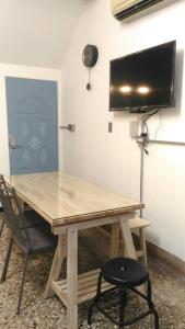 a wooden table with a television on a wall at i老宅2-安平漁光樂 in Tainan