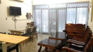 a living room with chairs and a table and a television at i老宅2-安平漁光樂 in Tainan