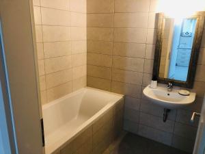a bathroom with a bath tub and a sink at Smart Chic Brasov in Braşov +21 photos