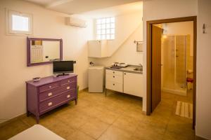 uma cozinha com uma cómoda roxa e um lavatório em On the beach em Torre Lapillo